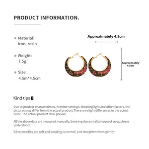 Detailed view of resin hoop earrings with tri-color crackle pattern and silver pins