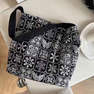 Retro black canvas shoulder bag featuring intricate white butterfly embroidery pattern