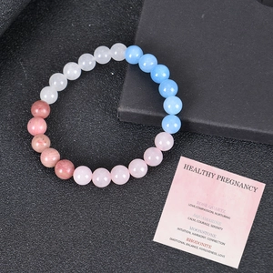 Bracciale energetico gravidanza con quarzo rosa e acquamarina su portagioie elegante
