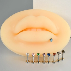 G23 titanium heart-shaped cubic zirconia labret studs displayed on a silicone lip model