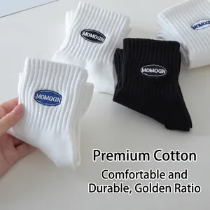White and black cotton crew socks with ribbed cuffs and blue letter embroidery