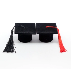 Detail view of mini black velvet graduation cap jewelry boxes with black and red tassels