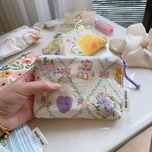 Hand holding floral cotton coin purse with zipper and cute patterns for storage