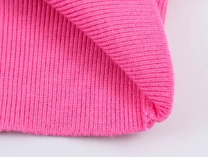Macro shot of vibrant pink ribbed knit fabric showing soft texture and detailed stitching
