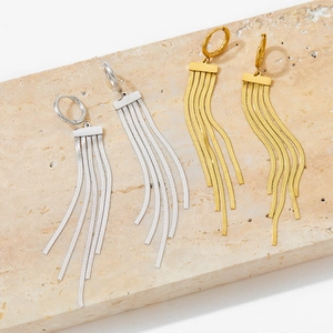 Elegant gold and silver long tassel earrings with snake chain on natural stone background