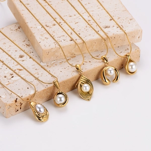 Colliers vintage dorés avec pendentifs en perles présentés sur des supports en pierre