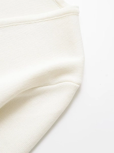 Close-up of premium cream-colored knitted fabric texture and fine stitching detail