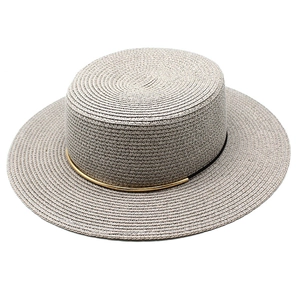 Dettaglio cappello di paglia grigio a corona piatta con elegante fascia in metallo dorato