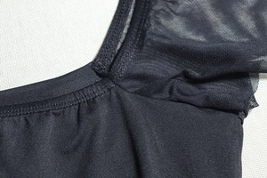 Detail of black dress shoulder with mesh stitching and fine flat-lock seam craftsmanship