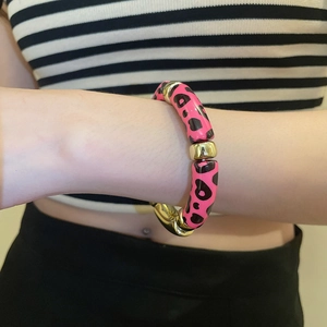 Détail d'un bracelet en perles acryliques à motif léopard rose et noir avec séparateurs