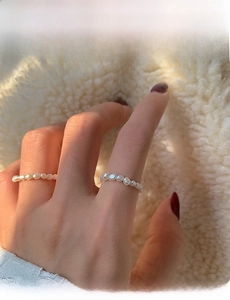 Close-up of 3-4mm natural freshwater pearl beaded rings on hand with sunset lighting