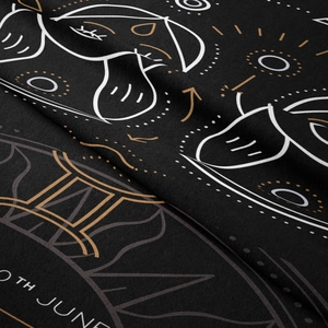 Macro detail of black bohemian tapestry showing woven texture and gold astrology print