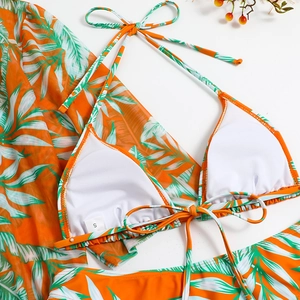 Flat lay of an orange bikini set with tropical print mesh cover-up and white padding inserts