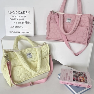 Detailed view of quilted cotton shoulder bags in pink and yellow with Cloud Hugger label