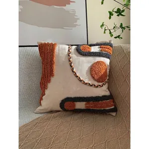 Bohemian tufted pillow cover with orange geometric patterns on beige cotton fabric