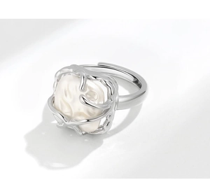 Detailed shot of an irregular vine silver ring featuring a large white baroque pearl
