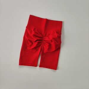 Detail of red high-waisted seamless biker shorts featuring scrunch butt lifting texture