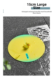 Detail of a 15cm yellow duck silicone floor drain cover on gray stone bathroom tile
