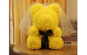 Detail of a yellow rose bear featuring a silver crown, bridal veil, and black ribbon bow