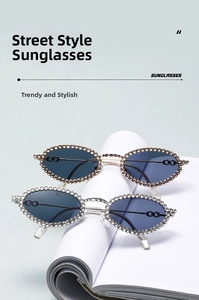 Detail of oval sunglasses featuring rhinestone-encrusted metal frames in gold and silver