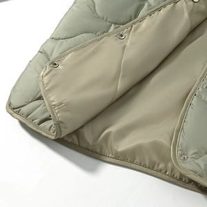 Detail shot of diamond quilted vest with metal snap buttons and smooth lining