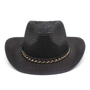 Primer plano de sombrero de vaquero de paja negra con cadena dorada y textura de tejido fino