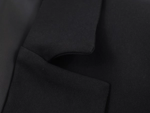 Close-up of black blazer lapel showcasing detailed twill fabric texture and tailoring