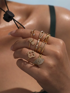Close-up of gold clover rings set with cubic zirconia and pearls on hand