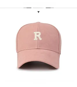 Detailed embroidery of white capital R letter on a pink cotton baseball cap