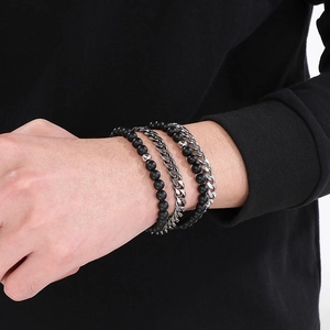 Detail of men's double-layer stainless steel Cuban chain and matte black agate bead bracelet