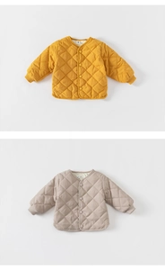 Detail of diamond quilted kids jackets in ginger and beige with ribbed cuffs