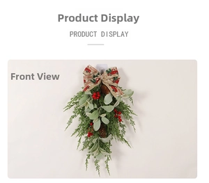 Detail of Christmas teardrop swag with pine cones, red berries and Merry Christmas bow