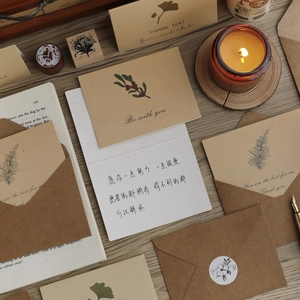 Vintage kraft paper envelopes and botanical flower greeting cards set on a wooden desk