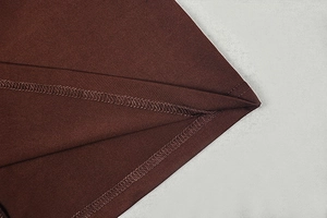 Detailaufnahme des dunkelbraunen Strickstoffs mit verstärkter Overlock-Nähtechnik