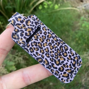 Detail view of purple leopard print lipstick holder keychain with silver metal ring