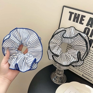 Three-dimensional layered striped fabric scrunchies in classic blue and black patterns