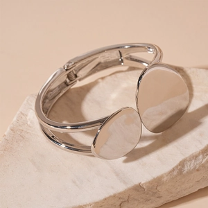 Detail of silver geometric open cuff bracelet featuring two polished circular discs on stones