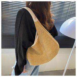 Detail of hollow woven mesh shoulder bag with white leather strap on a model