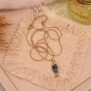Vue macro détaillée d'un collier pendentif carpe koi vintage 3D en émail bleu et or