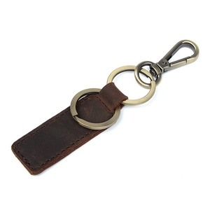Detail view of brown genuine leather keychain with bronze metal ring and spring hook