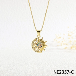 Detailed close-up of a moon and sun pendant necklace with colorful zircons on white paper