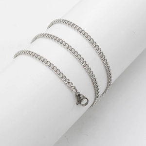 Detail of 3mm silver stainless steel curb chain with lobster clasp on a white cylinder
