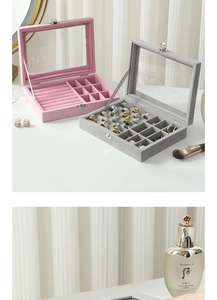 Detail view of pink and grey velvet jewelry box with glass window and ring slots