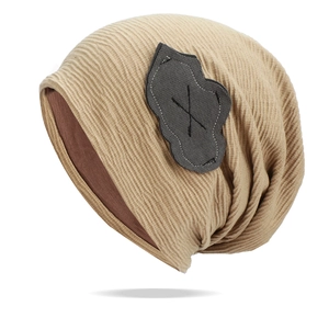 Detail of khaki ribbed knit beanie featuring cloud patch and soft brown lining