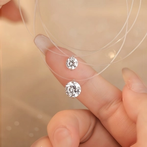 Collana minimalista in filo da pesca con pendente tondo in zircone sulle dita
