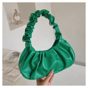 Detail of green ruched cloud bag showing soft PU leather texture and pleated handle