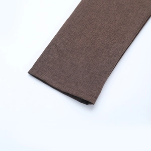 Close-up of the brown textured fabric and fine stitching on the long sleeve dress