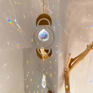 Modern gold moon crystal suncatcher creating colorful rainbow light spots on wall