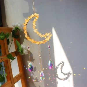 Detail of moon sun catcher with golden wire, yellow stones and crystal pendants