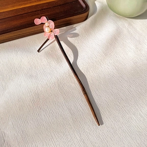 Detailed view of handmade wooden hair pin with pink resin flower and pearl tassel